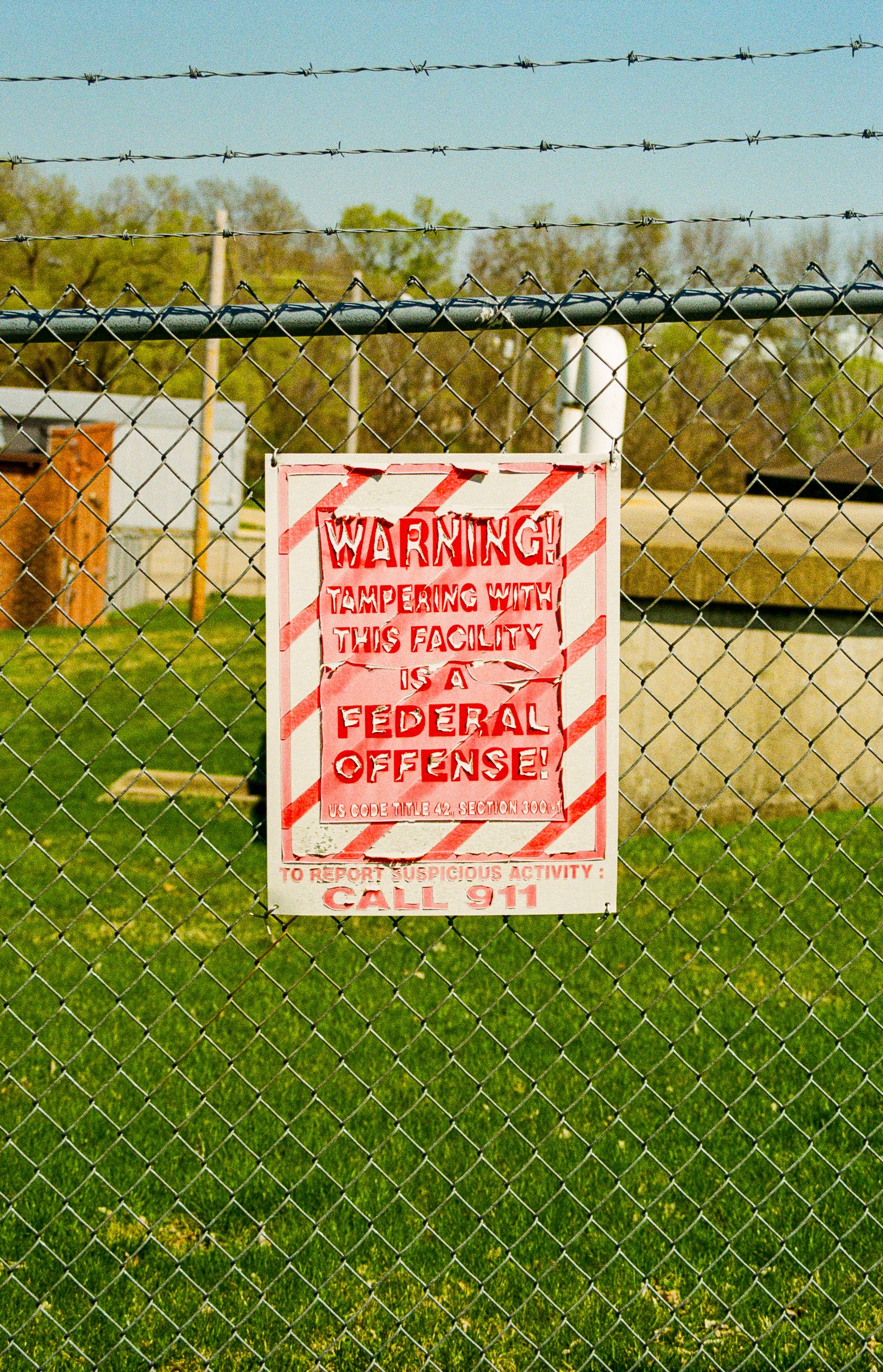 Warning Sign on Fence Protecting Federal Property · Free Stock Photo