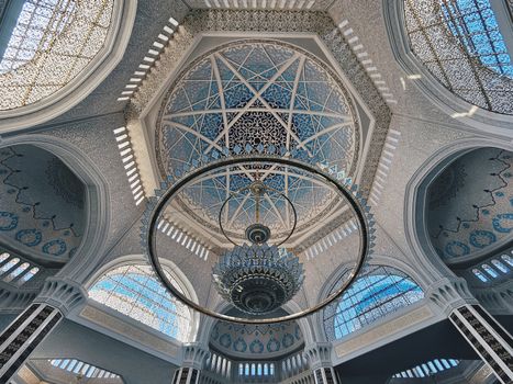 Explore the mesmerizing details of an ornate dome with exquisite geometric patterns and chandeliers.