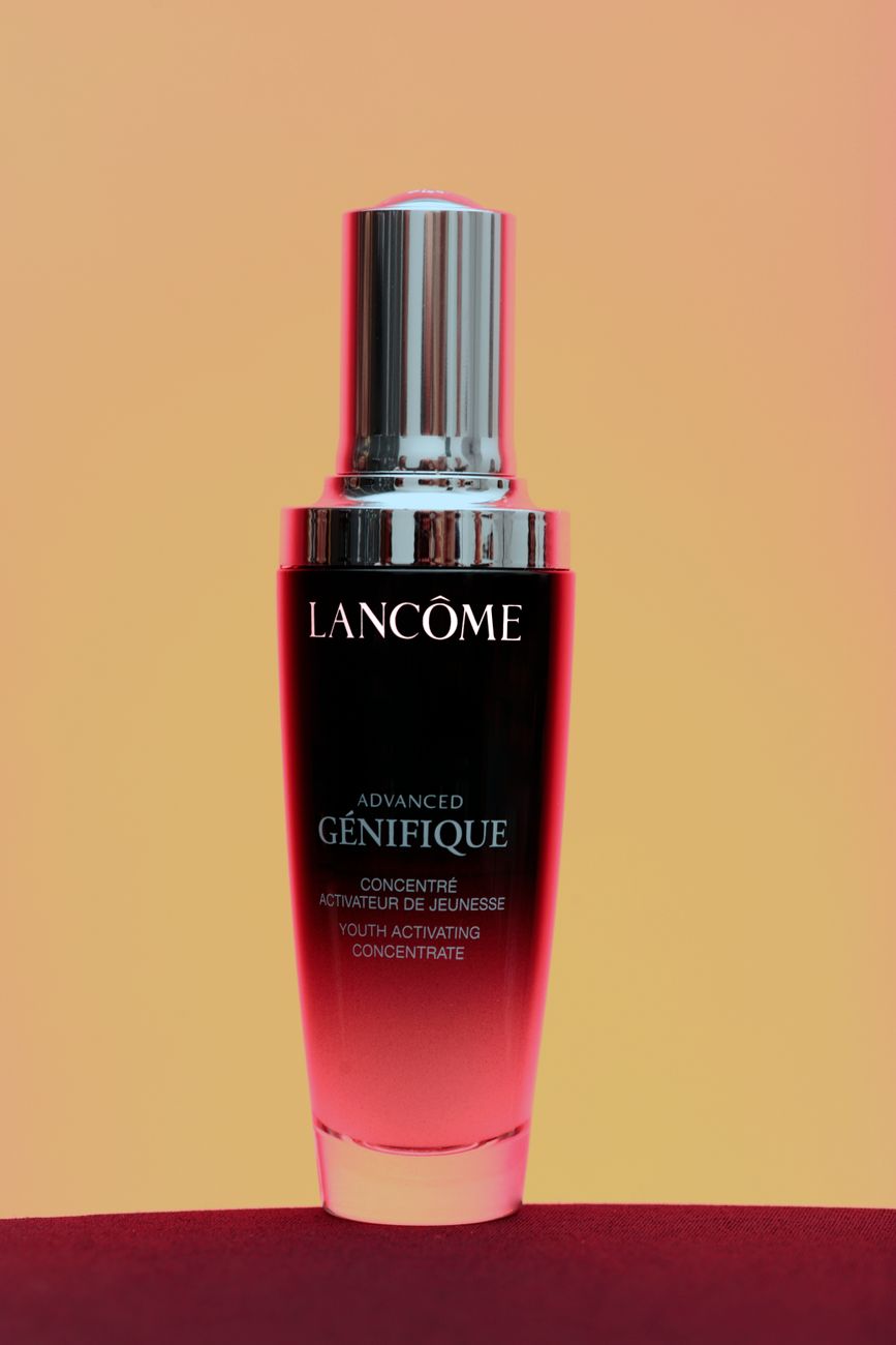 Lancôme Advanced Génifique serum bottle on a gradient background. Ideal for skincare and beauty themes.