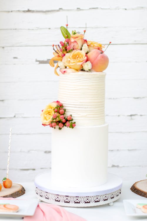 Photo De Mise Au Point Peu Profonde De Fleurs Jaunes Et Roses Sur Un Gâteau à Deux Niveaux