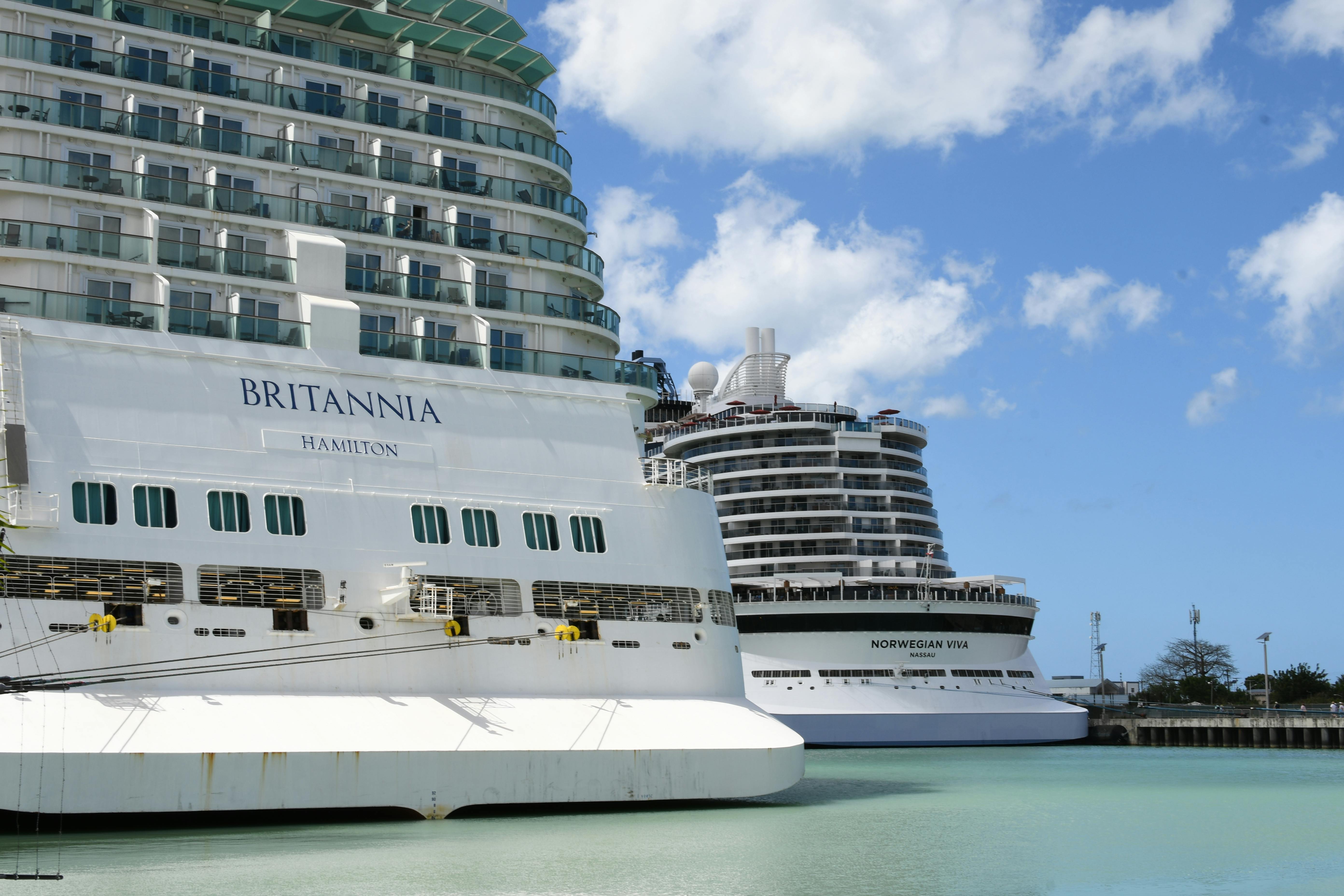 Cruise ships Britannia and Norwegian Viva docked at a picturesque port.