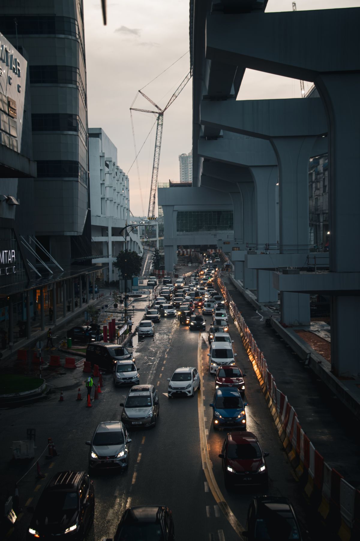 Evening traffic beside ongoing roadworks in Johor Bahru, Malaysia — the kind of live-road night job that needs mobile lighting