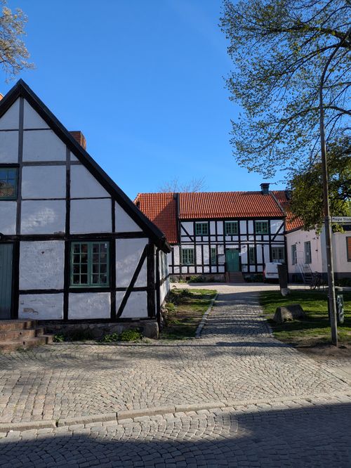 Free Traditional half-timbered houses under a clear blue sky, showcasing classic architecture and spring greenery. Stock Photo