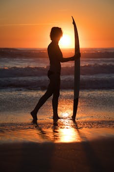Silhouette of a woman with a surfboard at sunrise on Melbourne Beach, Florida.