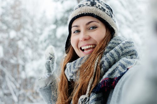 Woman Smiling While Wearing Grey and Black Scarf