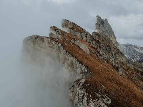 意大利多洛米蒂山脉塞塞达山峰的戏剧性雾景，在秋天展现