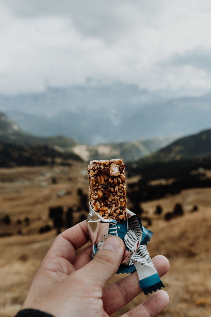 person holding a protein bar in natur