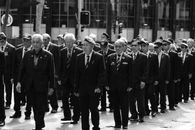 Black and white photo of veterans marching in a Sydney parade, showcasing unity and honor.