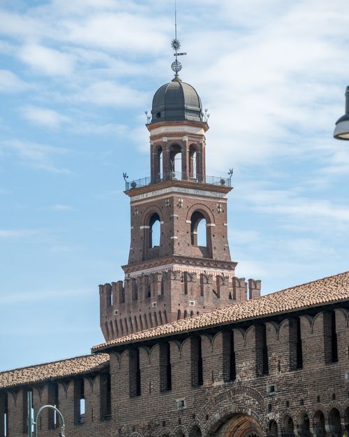 Free View of the iconic brick tower of Sforza Castle in Milan, Italy, under a clear sky. Stock Photo