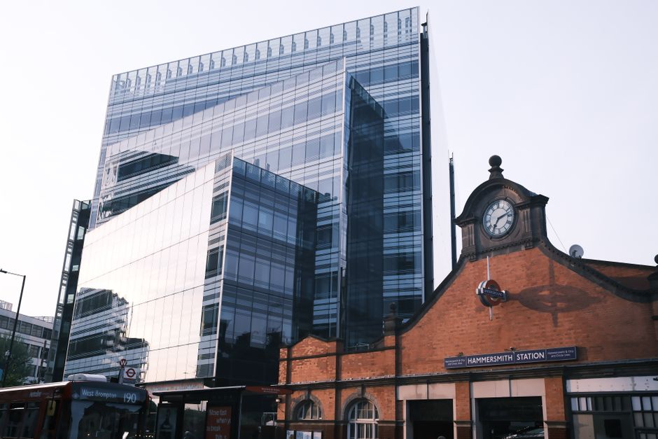 Hammersmith Station juxtaposed with modern glass building, London.
