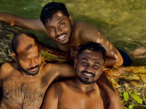 Free Three joyful friends swimming in a natural setting, enjoying summer vibes. Stock Photo