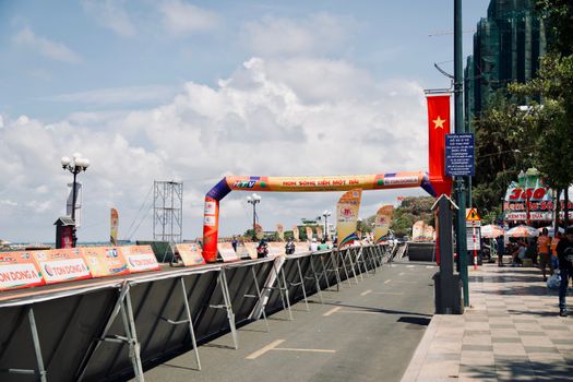 Vibrant street scene with decorative banners and a Vietnamese flag under a clear sky.