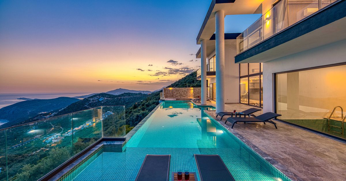 Luxury villa overlooking the ocean with an infinity pool at sunset