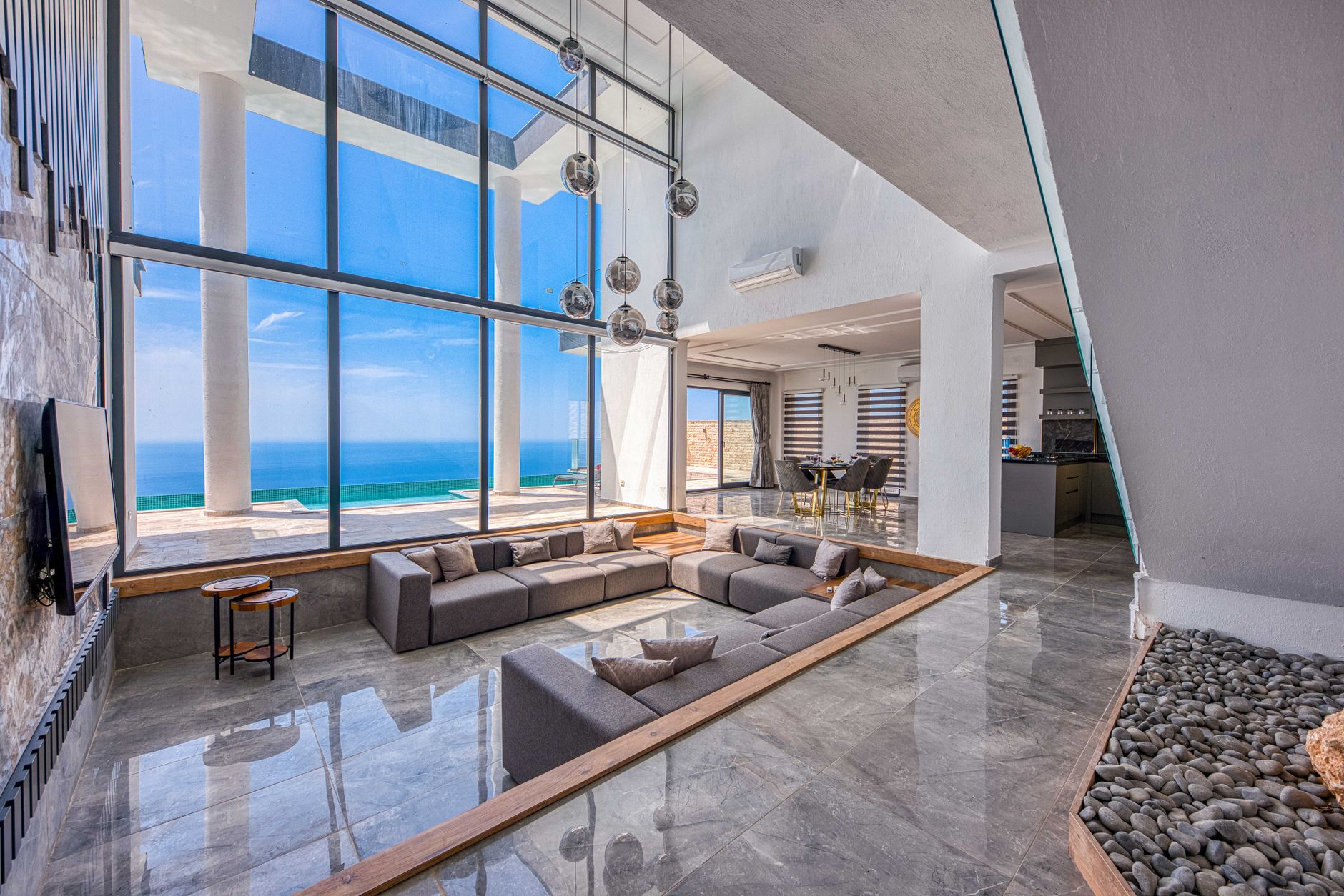 Interior de una villa de lujo con ventanales de suelo a techo integrados en el paisaje. Interior de una villa de lujo con ventanales de suelo a techo integrados en el paisaje.