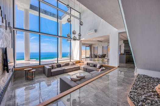 Spacious modern living room with stunning ocean view through large windows.