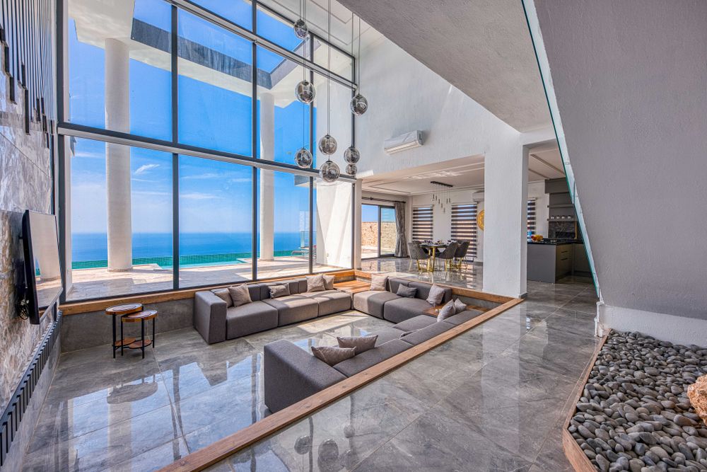 A sitting room with glass walls and a view of the sea