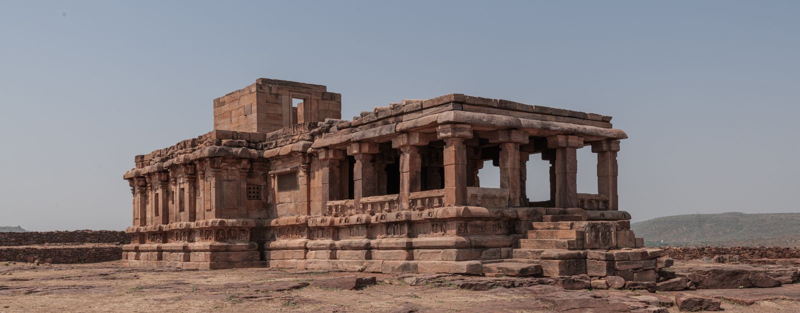 Explore the ancient temple ruins in Aihole, Karnataka, showcasing historic architecture under a clear sky.