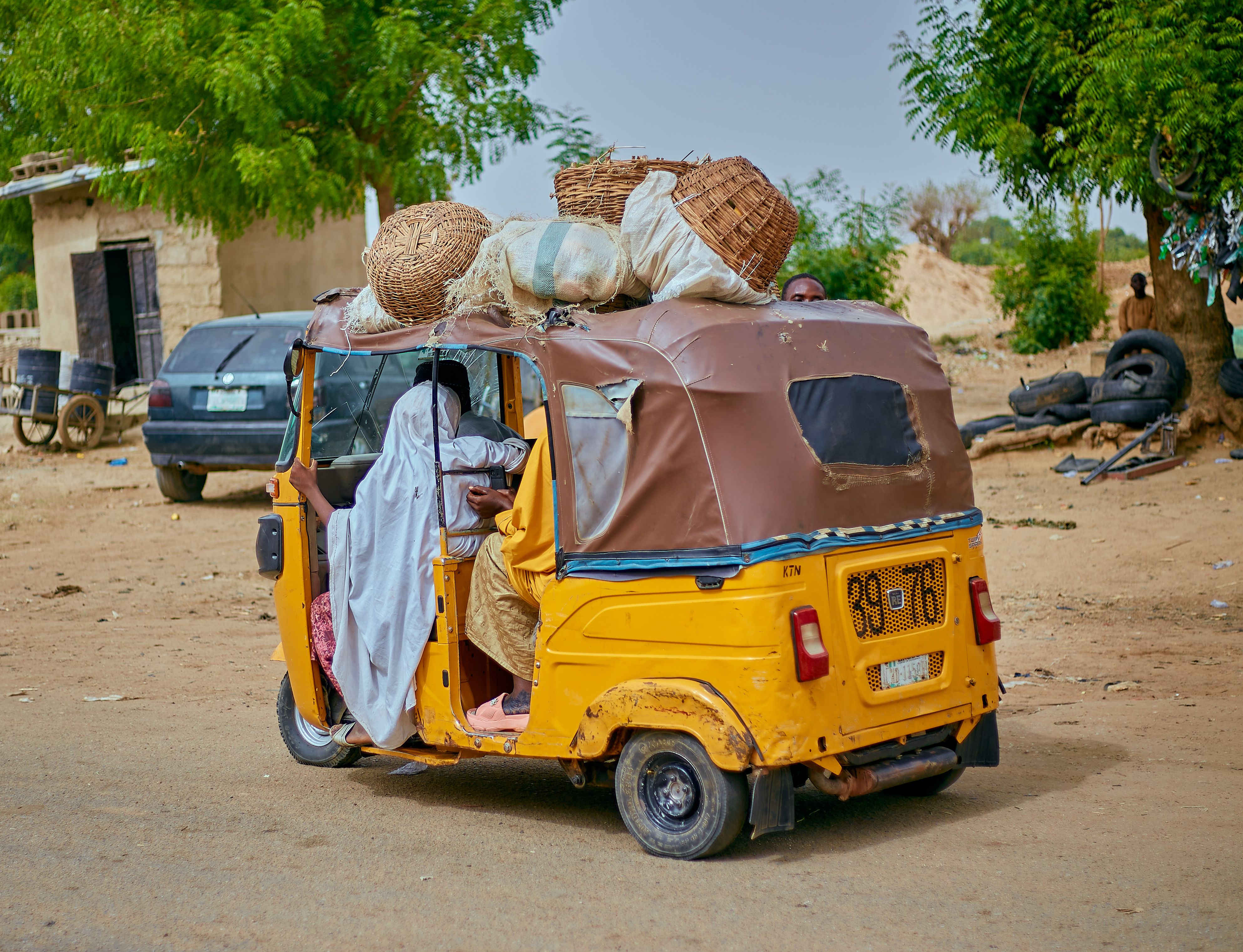 Yellow auto rickshaw with passengers and cargo · Free Stock Photo
