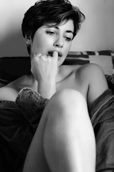 Artistic black and white portrait of a thoughtful woman in a serene, introspective pose.