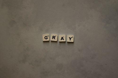 Free Gray Scrabble tiles on a textured background create a minimalist aesthetic. Stock Photo