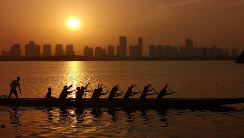 Silhouette of People Riding Canoe during Sunset
