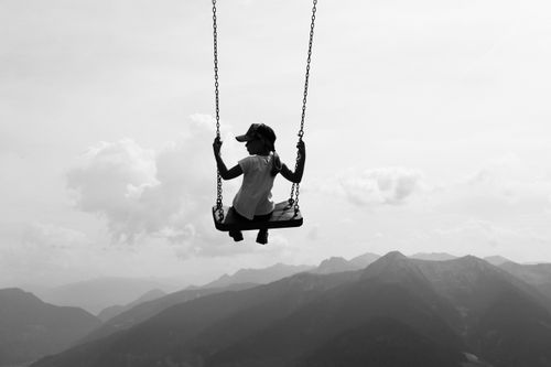 Free Silhouette of a woman swinging high above the mountains in Vipiteno, Italy, capturing a sense of freedom and adventure. Stock Photo