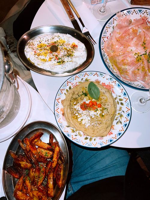 Free A vibrant assortment of Middle Eastern dishes including hummus, labneh, and roasted vegetables on a table. Stock Photo