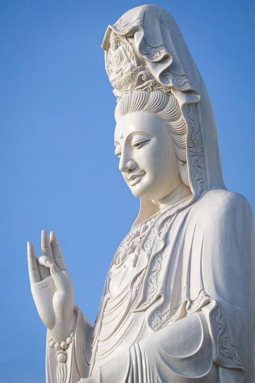 Free Close-up of a white Buddha statue against a vibrant blue sky in Ayutthaya, Thailand. Stock Photo