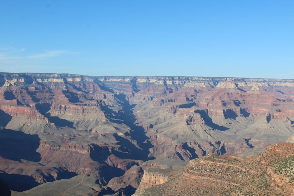 Explore the breathtaking beauty of Grand Canyon National Park under a clear blue sky.