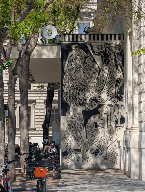 Free Black and white mural on an urban street with people enjoying a sunny day. Stock Photo