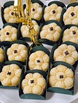 Appetizing close-up of flower-shaped marzipan with cloves, presented in decorative wrappers.