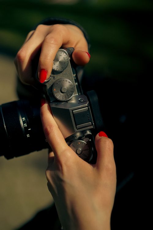 Free Elegant close-up of a person holding a vintage camera outdoors. Stock Photo