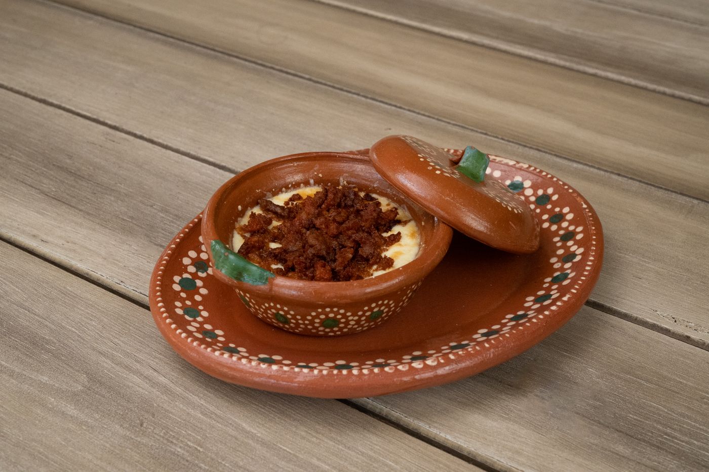 Appetizing queso fundido with chorizo served in a traditional Mexican clay dish.