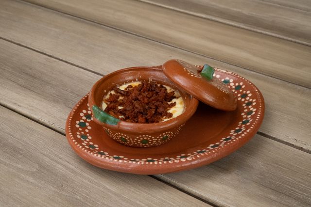 Appetizing queso fundido with chorizo served in a traditional Mexican clay dish.