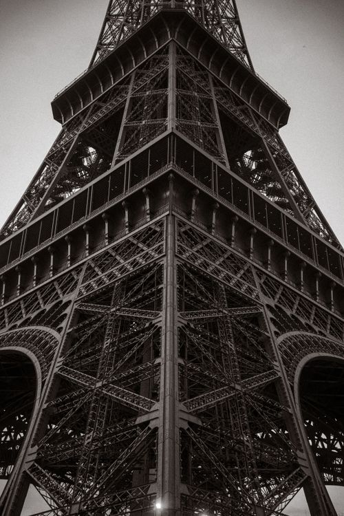 Free Close-up view of the Eiffel Tower showcasing its intricate iron lattice design, in a dramatic perspective. Stock Photo