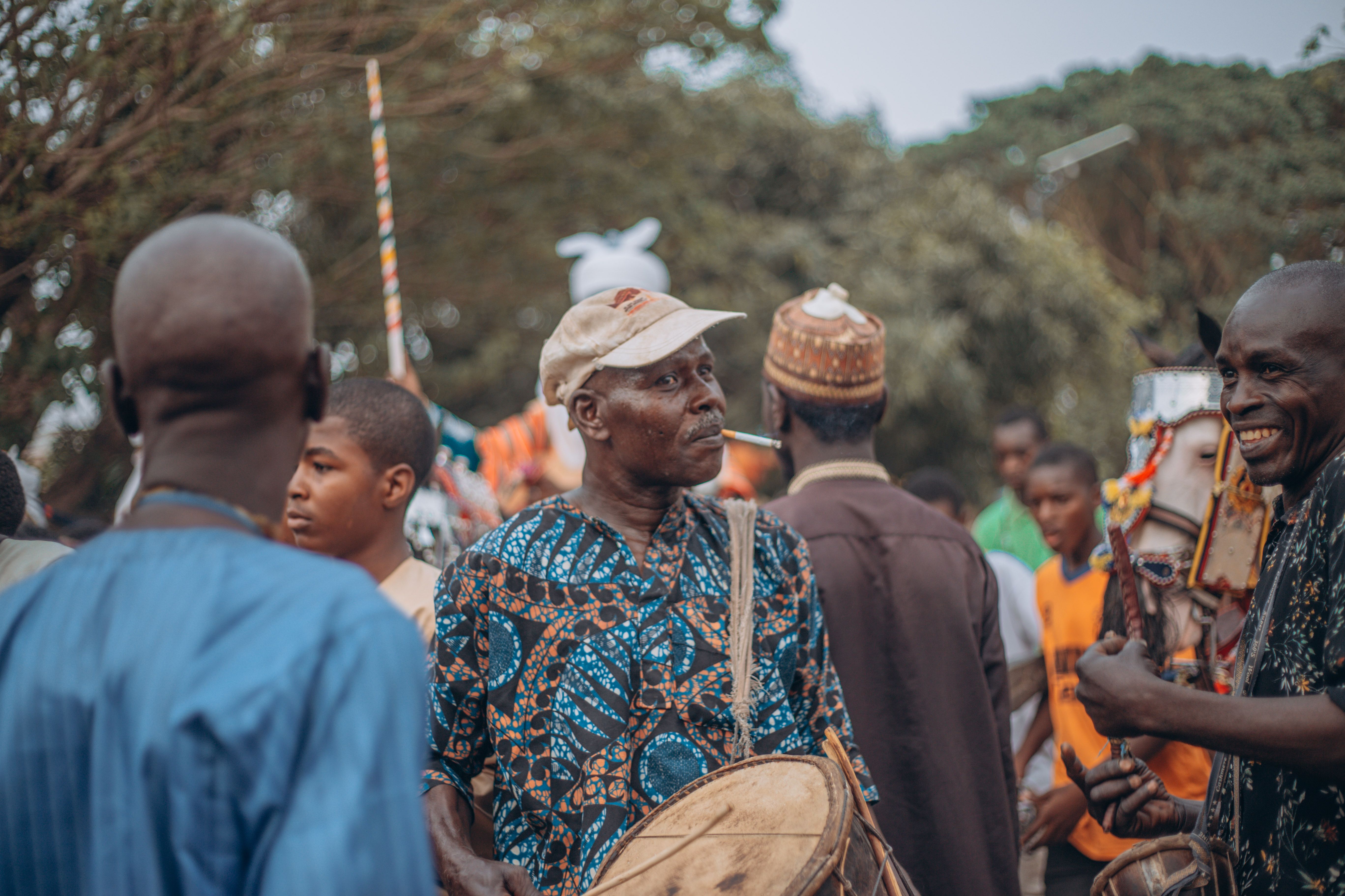 Colorful street festival scene featuring African drummers and lively crowd in traditional attire.