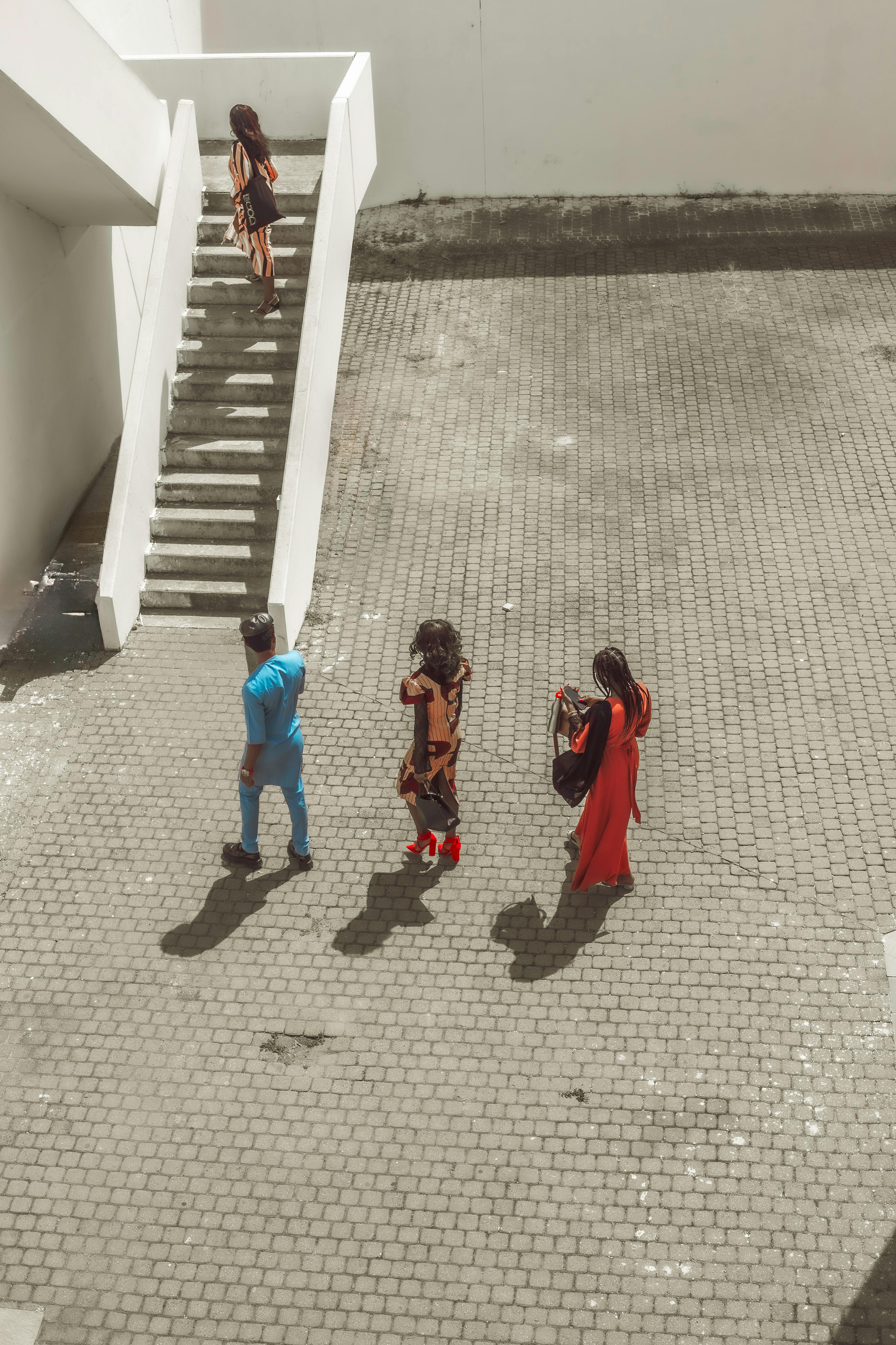 Gratuit Quatre adultes marchant dans un environnement urbain moderne photographiés d'en haut. Photos