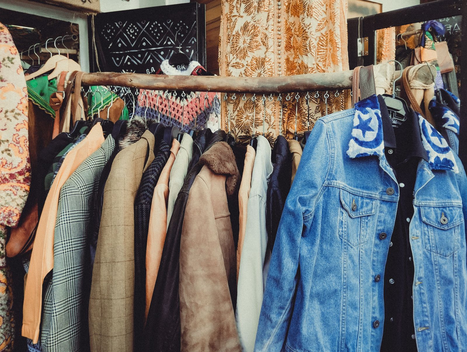 Heavy cotton jackets hung close together on a wooden rack