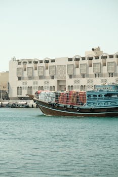 A traditional wooden boat moored by the Dubai Creek, showcasing classic architecture and cultural heritage.