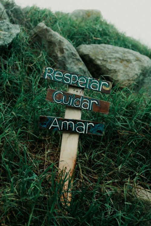 Free A wooden sign with words 'Respetar, Cuidar, Amar' on a grassy hill with rocks, Mar del Plata. Stock Photo