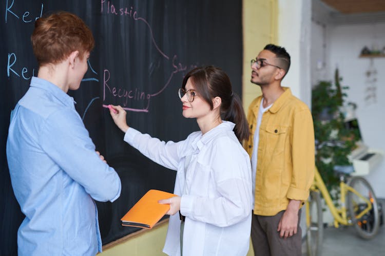 Photo Of Woman Writing On Blackboard