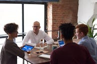 在现代化的办公环境中，多元化的团队正在合作，桌上摆放着笔记本电脑和笔记