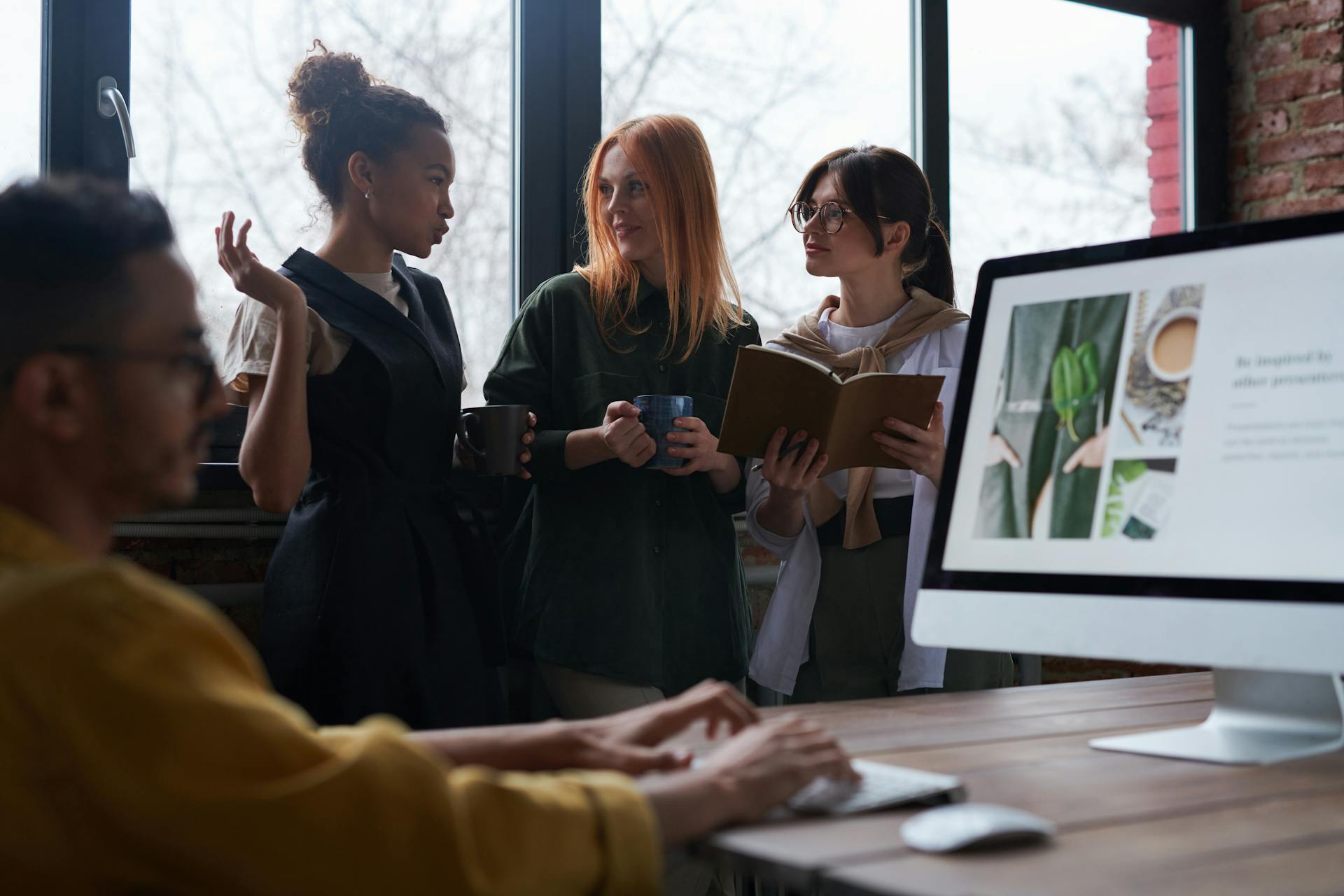 Diverse team engaged in discussion and collaboration in a modern office.