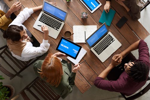 議論しながらmacbookを使用している人々のグループの上面写真