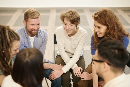 A diverse group of people smiling and collaborating indoors during a team meeting, promoting teamwork and cooperation.