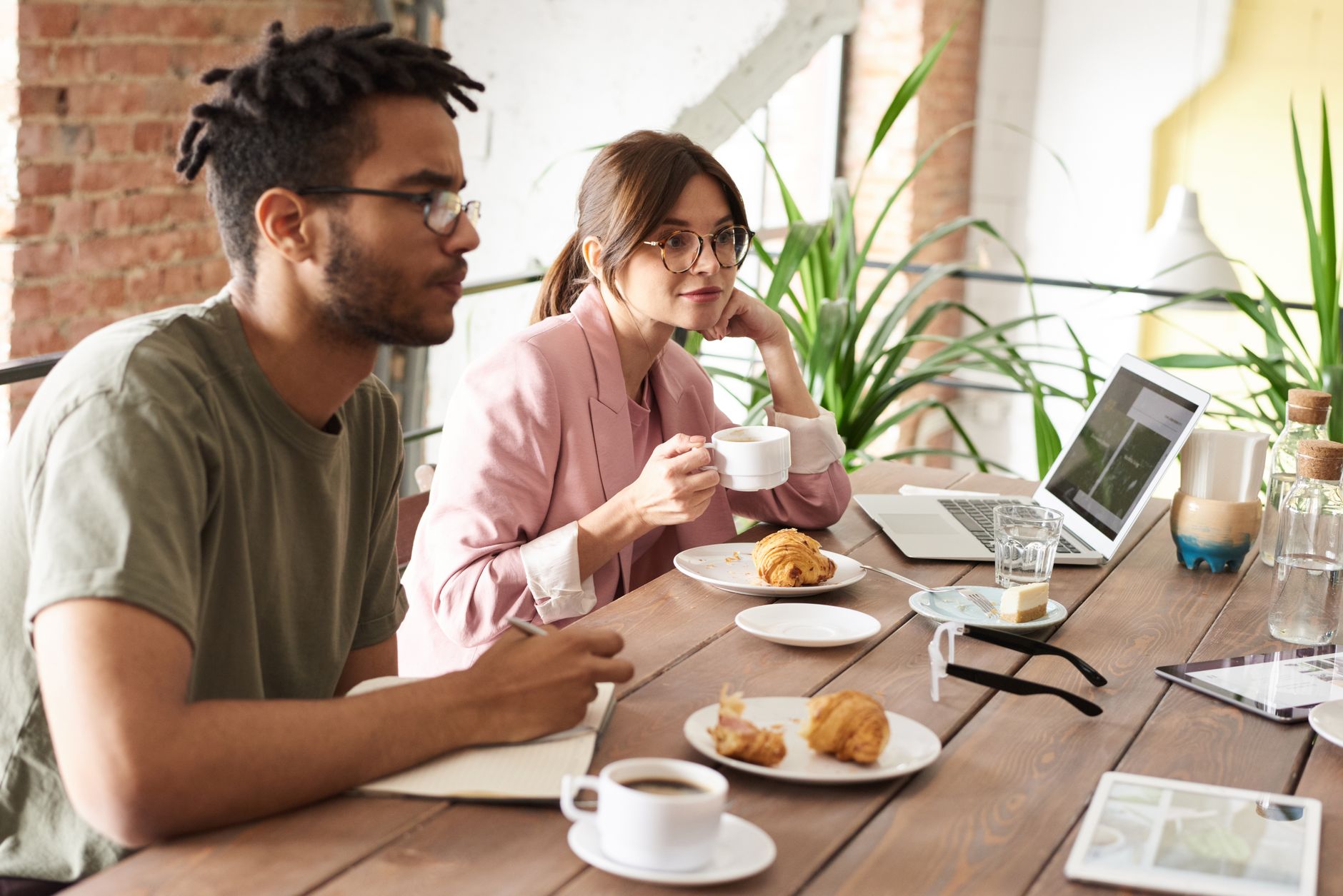 The Easiest Keto Breakfast Ideas Ever! 1 Two colleagues enjoying coffee and pastries while collaborating on a project indoors.
