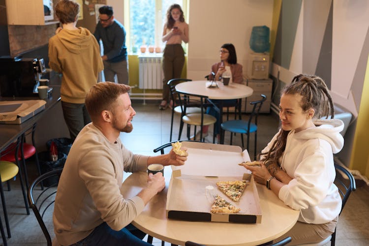 Man And Woman Eating Pizza Indoors