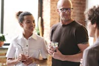 一群成年人在温暖友好的氛围中，一边享用饮料一边交谈