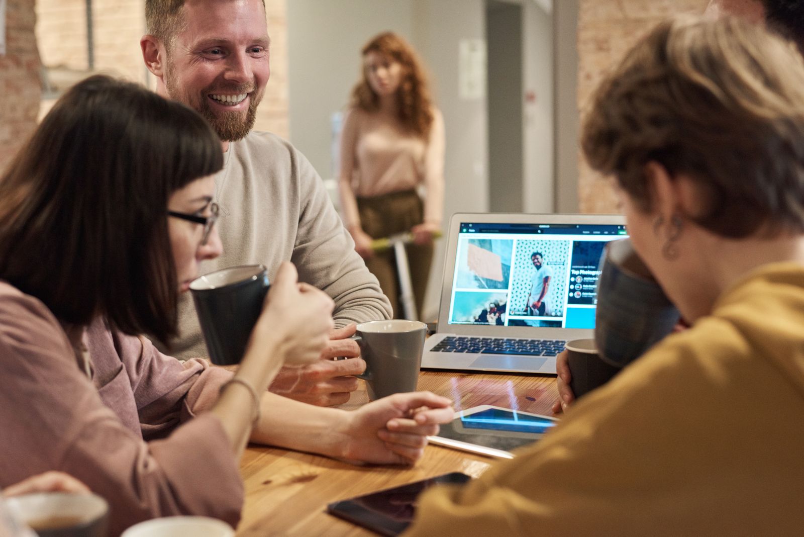 Colleagues collaborating in a bright office, focusing on a laptop screen