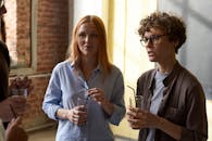 一群成年人在室内休闲地喝着饮料聊天